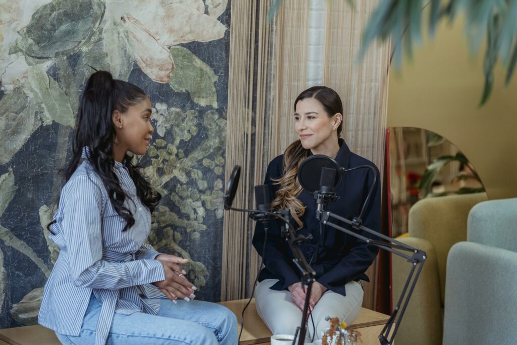 Deux animatrices du podcast d’introspection La Nébuleuse discutent dans un studio d’enregistrement avec micro